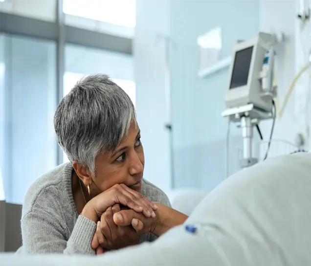 Nurse checking a feeding tube setup for a bedridden patient