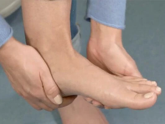 Person with diabetes checking the sole of the foot for cuts, redness and other signs of injury